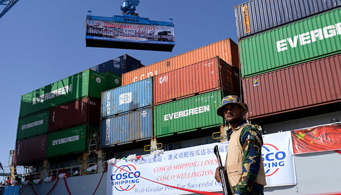 A Naval personnel stands guard beside a ship carrying containers during the opening of a trade project in Gwadar port. — AFP/File