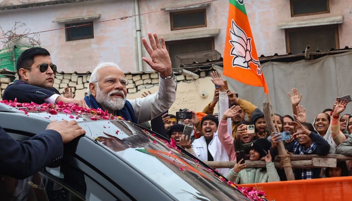 This photograph on December 30, 2023 shows Indias Prime Minister Narendra Modi (2L) greeting people during a roadshow in Ayodhya. — AFP