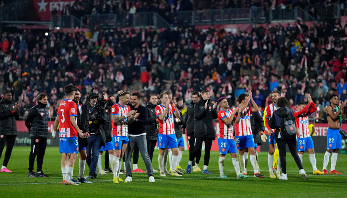 Gironas Spanish coach Michel (C,L) and team members celebrate victory at the end of the Spanish league football match between Girona FC and Club Atletico de Madrid in Girona on January 3, 2024. — AFP