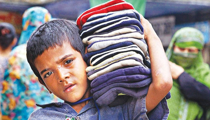 A child carries clothes to sell to customers. — AFP/File