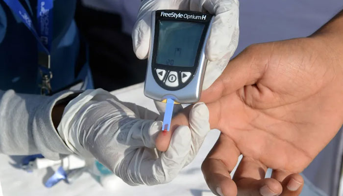 The image shows a diabetes test being conducted. — AFP File