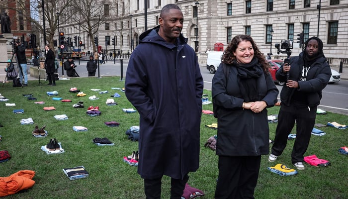 British actor Idris Elba (L) walks among clothing representing the human cost of UK Knife Crime displayed in Parliament square, central London, on January 8, 2024, as he launches a campaign against knife crime. — AFP