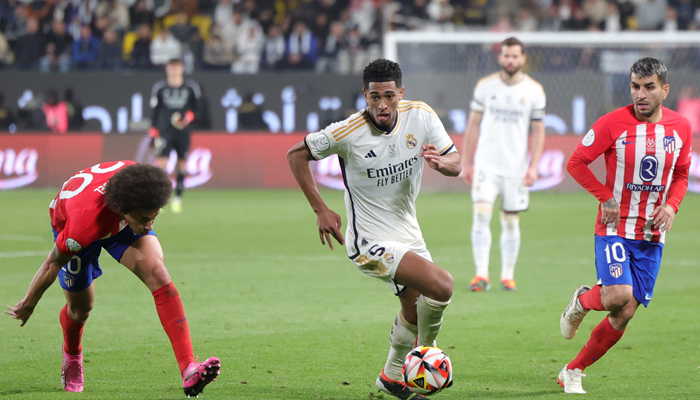 Real Madrids Jude Bellingham runs with the ball as he is marked by Atletico Madrids Axel Witsel during the Spanish Super Cup semi-final football match at the Al-Awwal Park Stadium in Riyadh, on January 10, 2024. — AFP