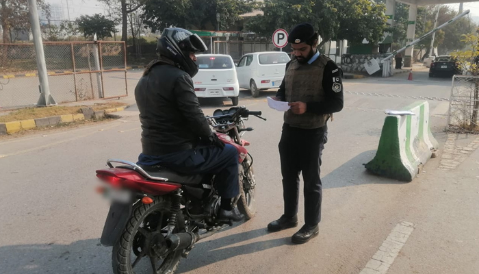 An Islamabad Police official can be seen checking a citizens documents on January 10, 2024. — Facebook/Islamabad Police