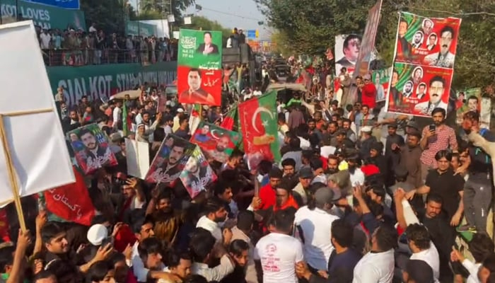 PTI workers in front of former party chairman Imran Khans vehicle at Zaman Park in Lahore, on March 13, 2023, in this still taken from a video. — Twitter/PTI