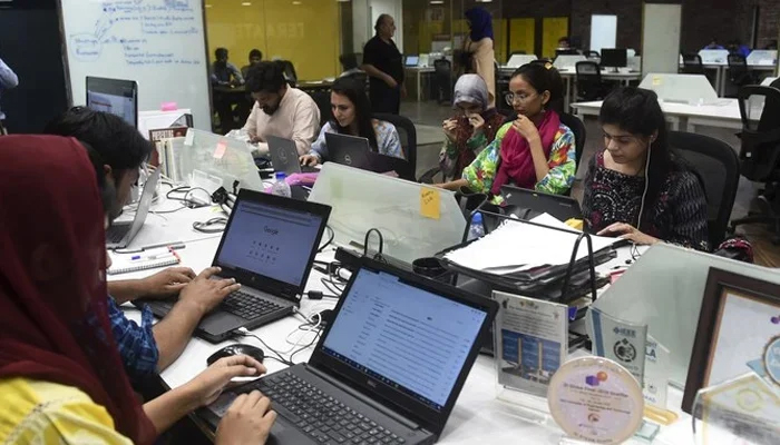 This photograph shows women working alongside men at their stations at the National Incubation Centre (NIC), in Lahore.—AFP/ File