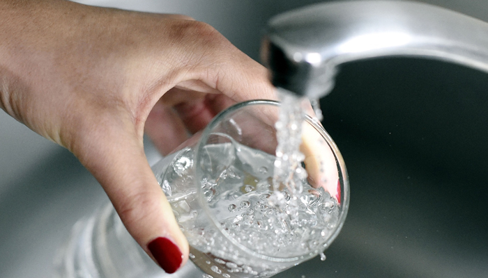 This representational image shows a person filling a glass of water. — AFP/File