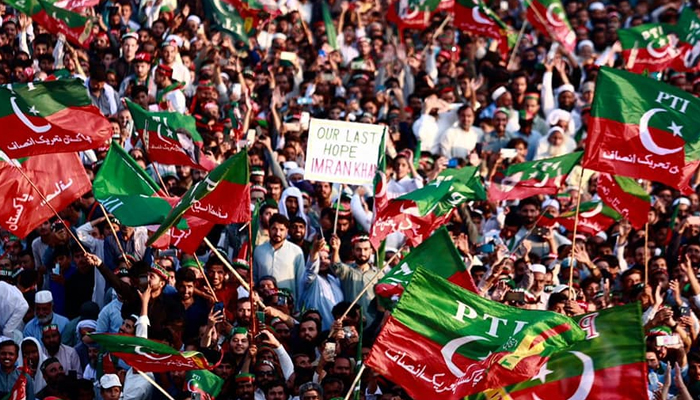 Supporters of Pakistan Tehreek-e-Insaf wave party flags during a party rally on October 13, 2022. — Facebook/Imran Khan