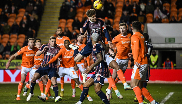 Nottingham Forests Chris Wood (C) heads the ball during the English FA Cup third-round replay football match against Blackpool at Bloomfield Road stadium, northern England on January 17, 2024. — AFP