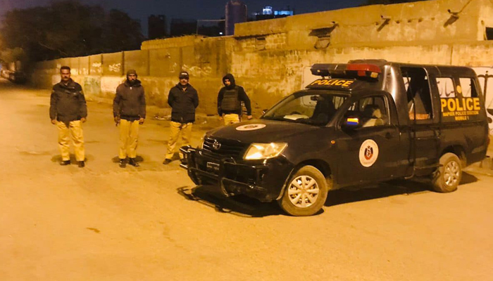 This image shows Karachi Police officials standing aside their vehicle in Karachi on January 6, 2024. — Facebook/Karachi Police - KPO