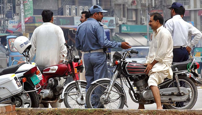This image shows a traffic police official interacting with a citizen. — Traffic Police Punjab website