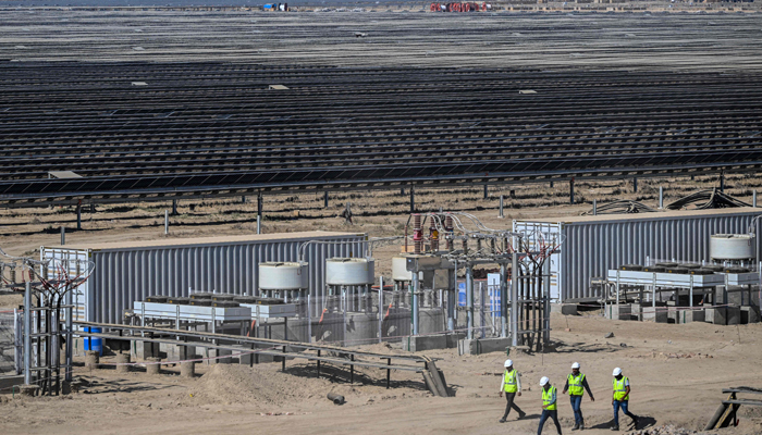 This photograph taken on January 12, 2024, shows employees at the Adani Group-owned Khavda Renewable Energy Park in Khavda. — AFP