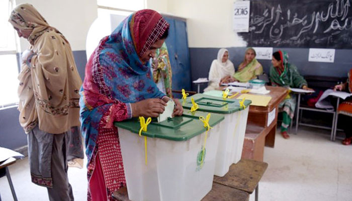 A woman casts her vote during Pakistans general election at a polling station in Islamabad on July 25, 2018. — AFP