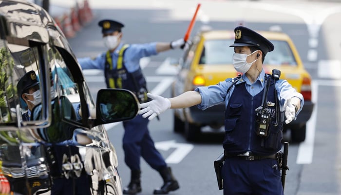 Police officers check vehicles near the US Embassy in Tokyo ahead of a visit by President Joe Biden. — Kyodo/File