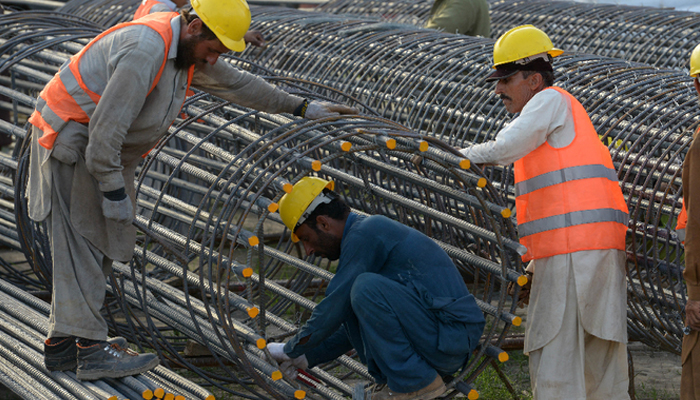 Pakistani laborers work at a construction site. — AFP/File
