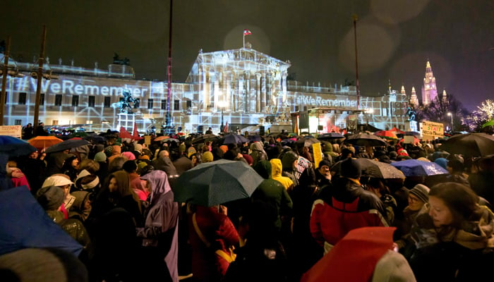 People take part in a rally under the motto Defend Democracy against right-wing extremism, racism and anti-Semitism as rain falls in front of the parliament in Vienna, Austria on January 26, 2024. — AFP