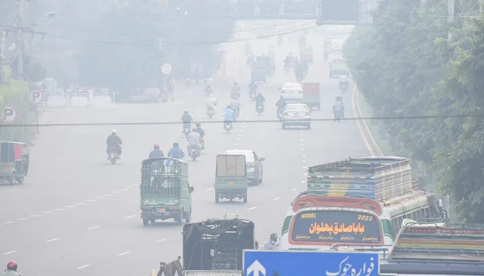 Commuters make their way along a road in Lahore. — AFP/File