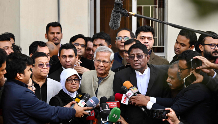 Bangladeshi Nobel peace laureate Muhammad Yunus (C) addresses the media as leaves a court in Dhaka on January 28, 2024. — AFP