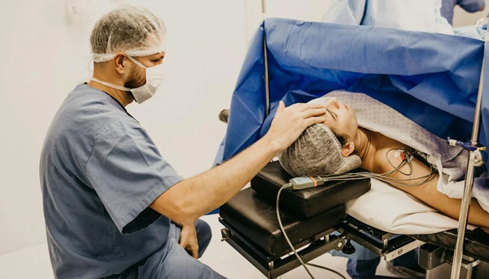 In this representative image, a healthcare official treats a patient. — Pexels