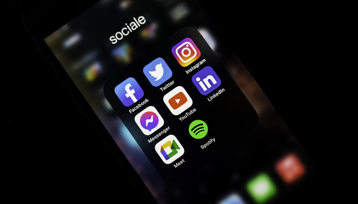 A representational image of a phone screen showing social media icons. — Unsplash