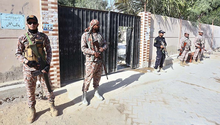 Security officials standing on high alert outside the polling station. — APP/File