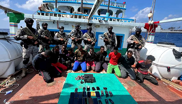 This photograph taken on January 30, 2024, shows Indian commandos standing guard with a group of detained pirates after the Indian Navy freed an Iranian fishing vessel hijacked by Somali pirates, off the Somali coast. — AFP