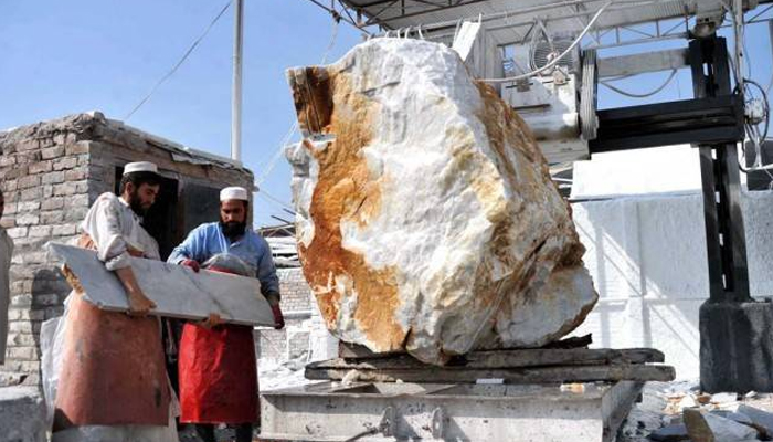 This image shows tow laborers working in a Marble factory. — AFP/File