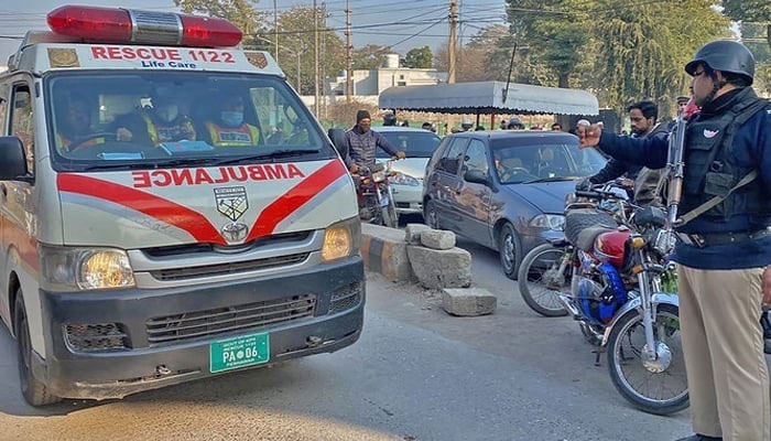 A police official guides an ambulance on the road in KP. — AFP/File