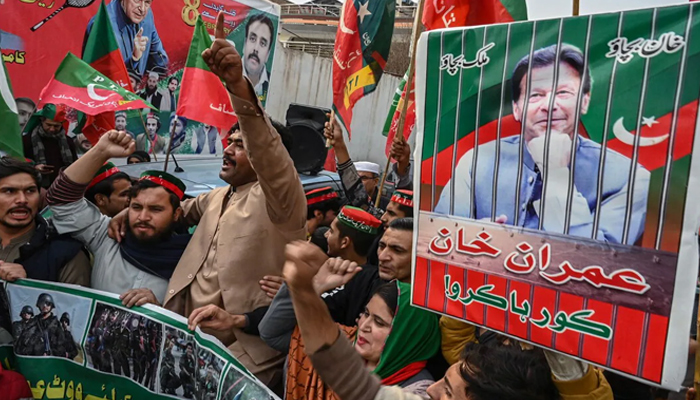 In this picture, PTI workers are seen carrying PTI flags and banners of their party Leader Imran Khan. — AFP/File