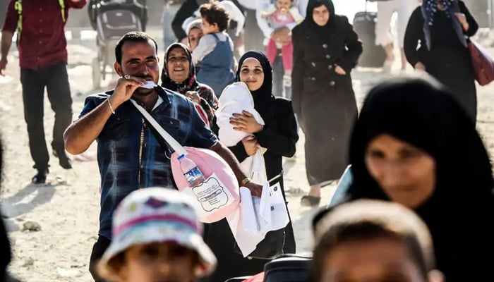 This image shows Syrian families feeling the warzone in Syria. — AFP/File