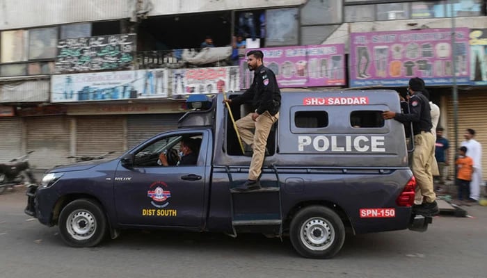 Police personnel can be seen on a police vehicle in Karachi. — AFP/File