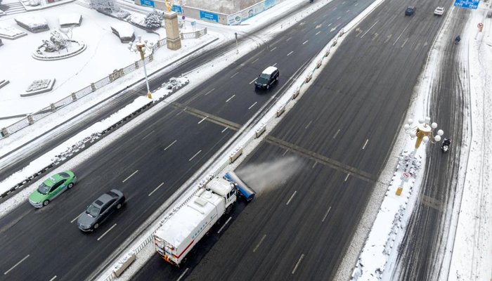 An aerial drone photo shows snow sweeper clearing a road in Qingjiangpu District of Huaian City, east Chinas Jiangsu Province, Feb. 4, 2024. — Xinhua