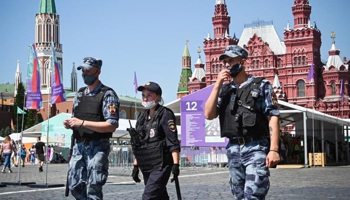Russian police and National Guard servicemen wearing face masks walk along Red Square in central Moscow. — AFP