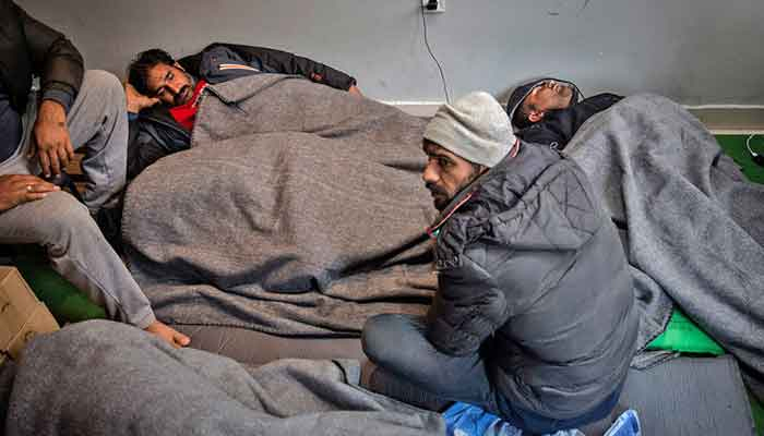 Migrants and refugees from Pakistan rest at a migrant center in Belgrade. — AFP/File