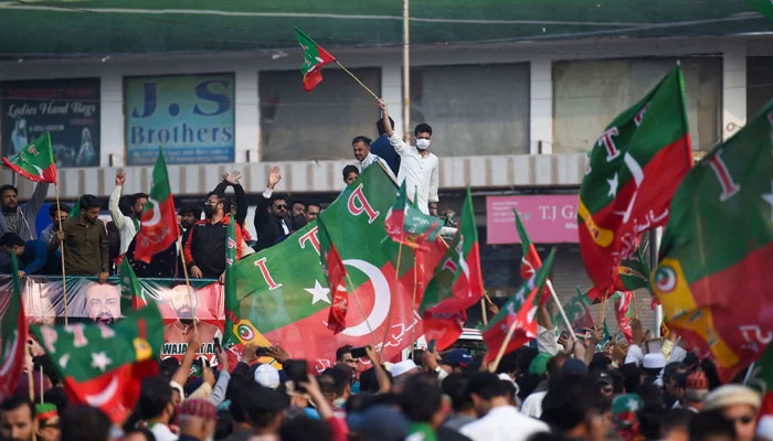 Supporters of the Pakistan Tehreek-e-Insaf (PTI) holds party flags in Karachi on January 28, 2024. — AFP