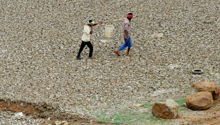 Workers carry water collected from the Puzhal reservoir outside Chennai, India. — AFP/File