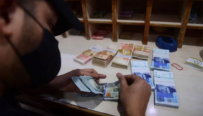 A currency exchange dealer counting $100 bills in this picture. — AFP/File