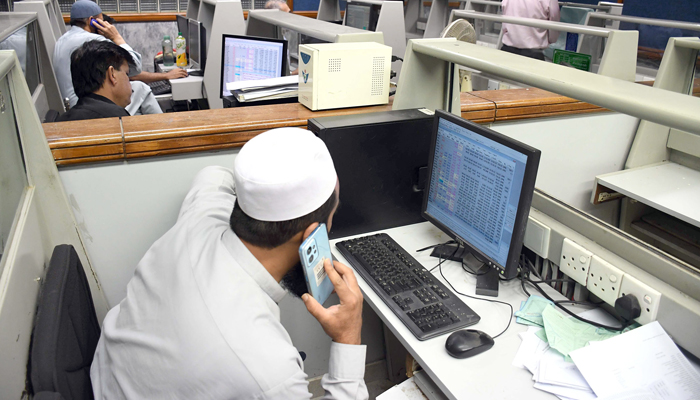 Stock brokers watch share prices during a trading session at the Pakistan Stock Exchange (PSX) in Karachi on February 13, 2024. — Online