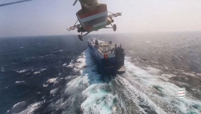 A Houthi military helicopter flies over the Galaxy Leader cargo ship in the Red Sea in this photo released on November 20, 2023. —  Houthi Military Media/Handout