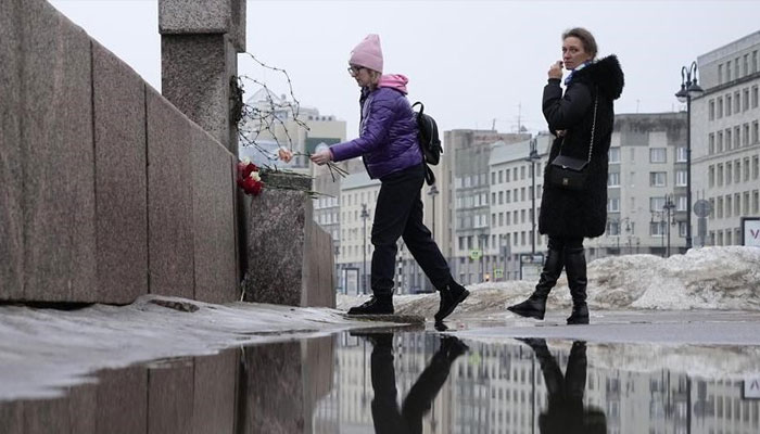 A woman lays flowers paying respect to Alexei Navalny at the Memorial to Victims of Political Repression in St. Petersburg, Russia, Saturday, Feb. 24, 2024. — AFP