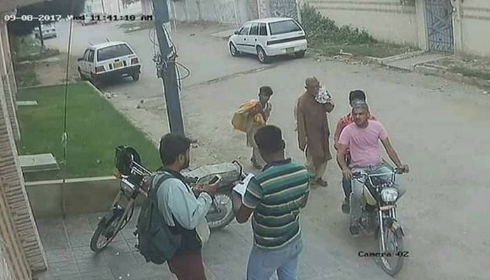 Still from a CCTV footage showing a robbery at gunpoint in Karachi. — Facebook/TheTimesOfKarachi