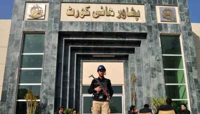 A police official stands guard outside the Peshawar High Court (PHC) in this file photo. — APP File