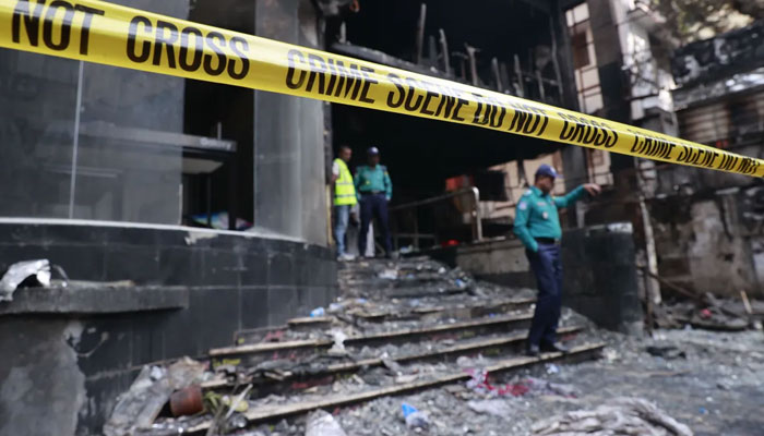 Police officers stand outside the commercial building on Bailey Road in Dhaka. — EPA