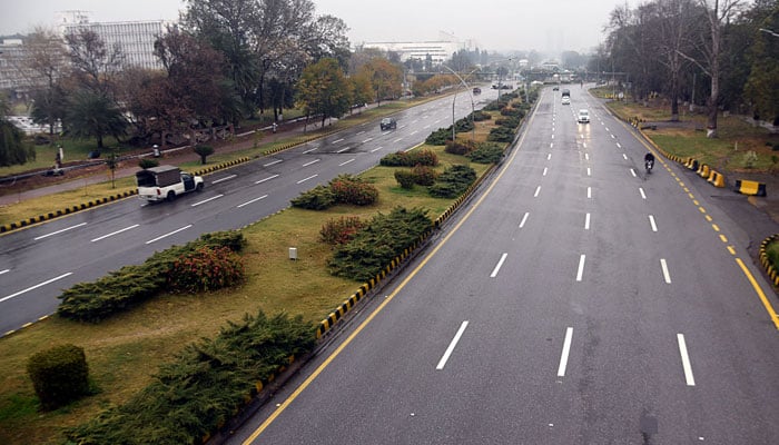 Motorists on their way on Constitution Avenue during rain in Islamabad. — Online/File