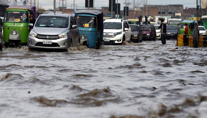 Vehicles can be seen stuck on the road after heavy rain in Peshawar. — INP/File