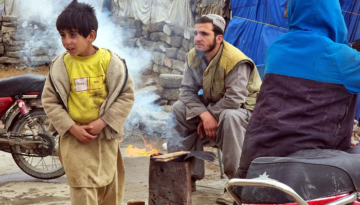 People warm their hands on bonfire to save themselves from cold waves during the winter season, in Quetta on March 1, 2024. — PPI