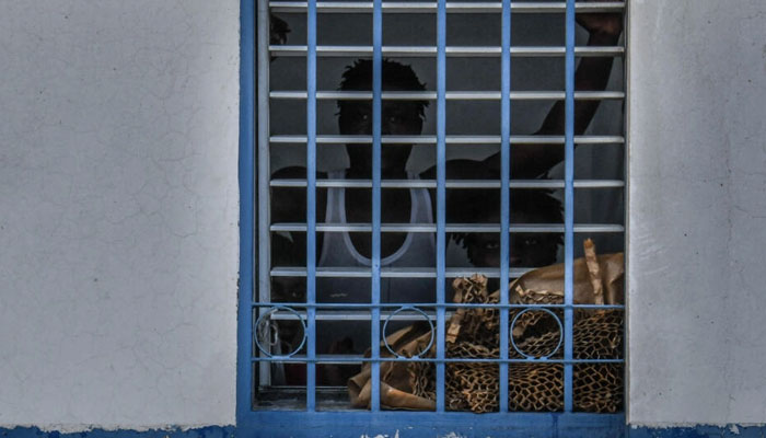 A prisoner looks out from his cell at Haitis National Penitentiary in Port-au-Prince, Haiti on August 30, 2019. — AFP