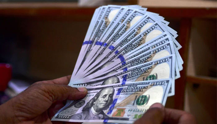 A foreign currency dealer counts US dollar notes at a currency market in Karachi on July 19, 2022. — AFP