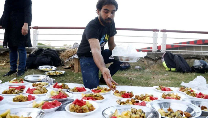 A man arranges food for Iftar at the roadside during the holy month of Ramadan. — Xinhua/File