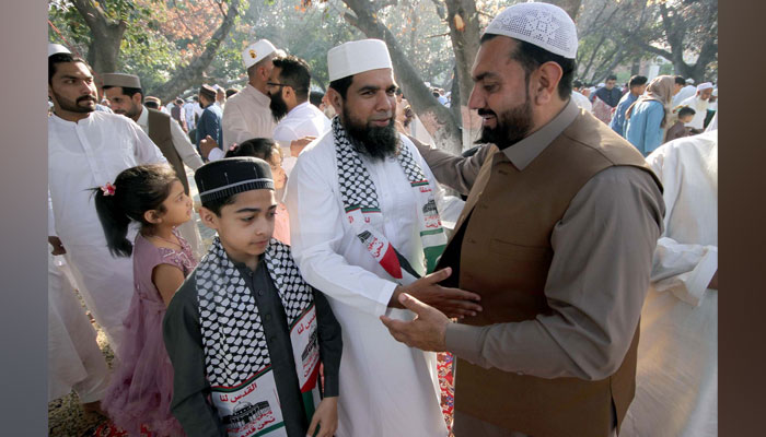 People embrace each other and exchange greetings after offering Eid-ul-Fitr prayers in Peshawar on April 12, 2024. — PPI
